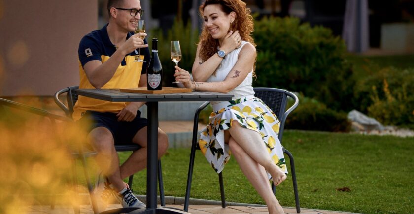 Fiatal pár a Tulipán Vendégház kerti tavánál romantikus hangulatban pezsgővel koccintanak